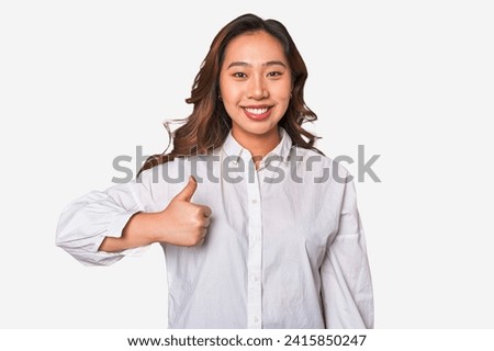 A young chinese woman smiling and raising thumb up