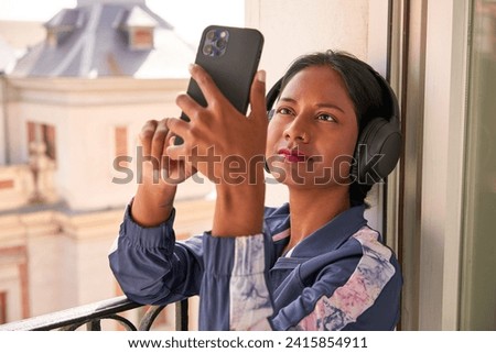 Music-loving Indian woman curates playlist on phone.