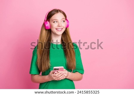 Photo of blonde hair girl millennial listening audio book looking empty space change playlist using phone isolated on pink color background