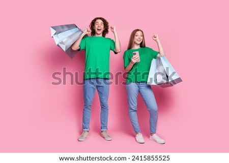 Full body size photo of two overjoyed teenagers raised fists up celebrate big sale aliexpress cheap prices isolated on pink color background