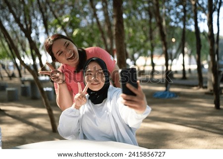 asian women in sportswear taking picture or selfie with phone
