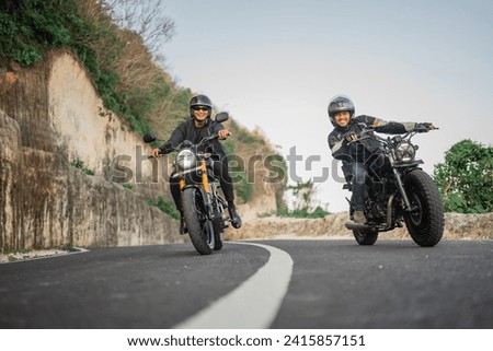 happy asian bikers riding motorcycle together, leisure activity concept Royalty-Free Stock Photo #2415857151