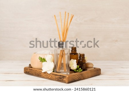 Spa composition with freesia flower and aroma diffuser on wooden table Royalty-Free Stock Photo #2415860121