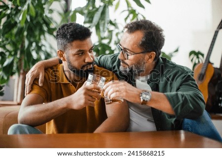 Best friends, supporting each other, drinking whiskey and talking. Discussing problems and drowning sorrows in alcohol. Concept of male friendship, bromance. Royalty-Free Stock Photo #2415868215