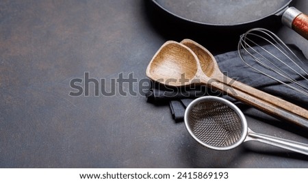 Culinary essentials: Diverse cooking utensils on stone table. With copy space Royalty-Free Stock Photo #2415869193