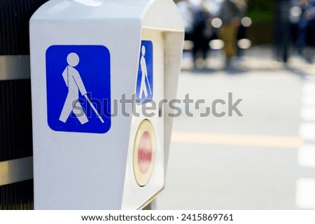 Equipment for blind people, symbol for disabled person for crossing the road at the traffic light pole, traffic signal button in Tokyo, Japan.