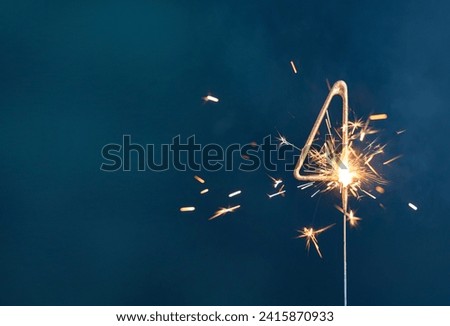 4 years celebration festive background made with Bengal fires in the form of number Four. Royalty-Free Stock Photo #2415870933