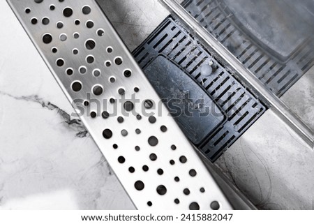 Stainless linear shower drain system  clogged with hairs. Royalty-Free Stock Photo #2415882047