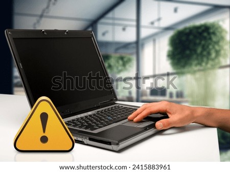 Warning sign on office table with computer