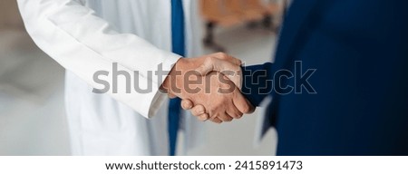 Close up of pharmaceutical sales representative shaking hands with doctor in medical building. Doctor greeting hospital director, manager in private clinic. Banner with copy space. Royalty-Free Stock Photo #2415891473