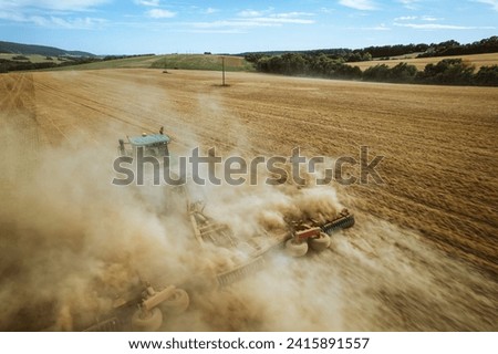 Aerial view of a tractor working in a field. Agriculture and cultivation of industrial farms. Agribusiness.