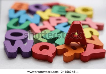 English Alphabet On A White Background. alphabets on a wooden surface. a - letter. scattered mixed colorful wooden letters of the English alphabet on backdrop, copy space, as a background composition