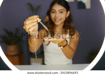 Teenage girl filming moisturizing essence review for her blog Royalty-Free Stock Photo #2415896693
