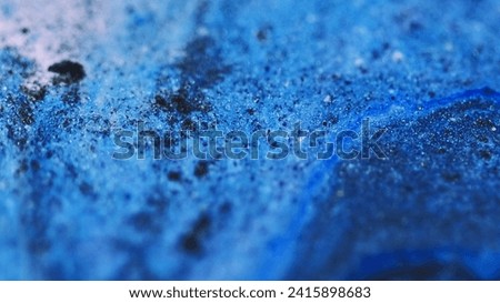 Wet glitter texture. Paint flow. Defocused blue black color shimmering particles acrylic ink water marble blend wave motion abstract art background.