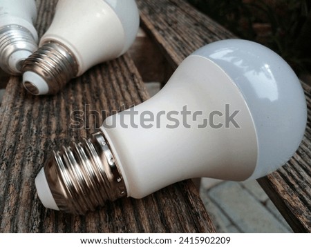 White light bulbs placed on wooden bench. Closeup photo.