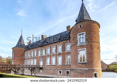 Alden Biesen Castle from 16th century, surrounded by the moat, wooden bridge, circular tower, brick walls, windows and gable roof, view from outer courtyard, cloudy day in Bilzen, Limburg, Belgium Royalty-Free Stock Photo #2415902519