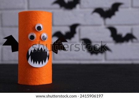 Spooky monster on black table, space for text. Handmade Halloween decoration
