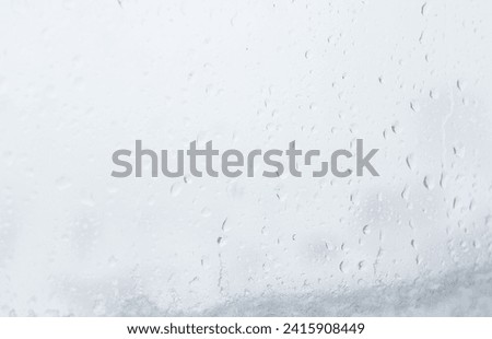 Glass window with raindrops, rainy weather day outside, abstract photo of cloudy mood, water close up