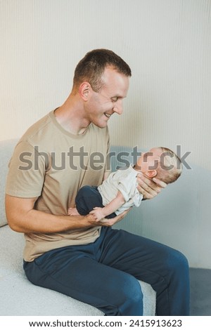 A happy young father holds his newborn son in his arms. Parenthood concept. Father and little son Royalty-Free Stock Photo #2415913623