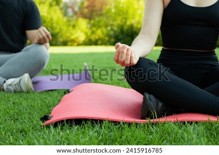 Couple of boy and girl doing yoga in the outdoor park. Sport with mats. Resting on the mat. Healthy lifestyle. Royalty-Free Stock Photo #2415916785