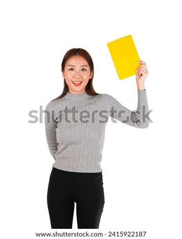 Excited young female asian teacher holding a yellow notebook against a white background