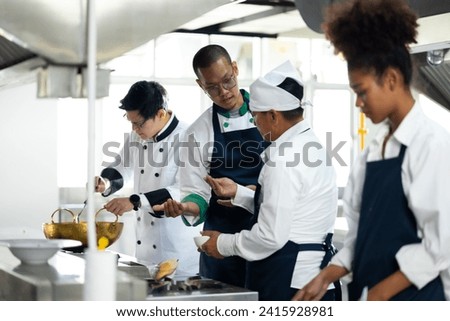 Group of student learning. Cooking class. culinary classroom. group of happy mature man and young woman multi - ethnic students are focusing on cooking lessons in a cooking school.  Royalty-Free Stock Photo #2415928981