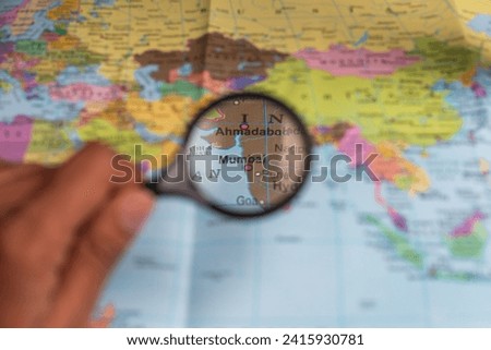 Mumbai India, magnifying glass close up with colorful world map.