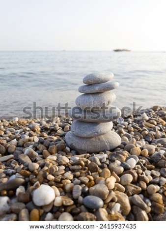 Pyramid of sea pebbles, composed by the sea. The object is in focus, the background is blurred.