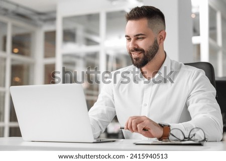 Smiling man working at table in office. Lawyer, businessman, accountant or manager