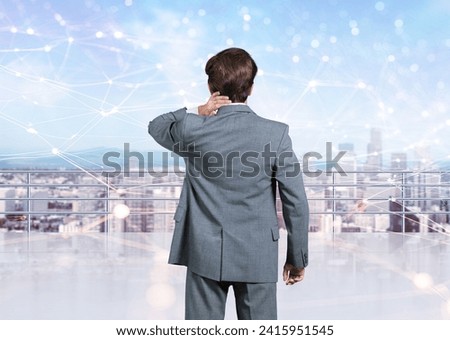 Businessman with office buildings in city at night.