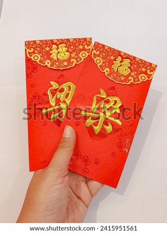 Angpao or THR envelope. Angpao is a gift in an envelope containing a sum of money to celebrate Chinese New Year. (Text translation = good luck and good luck)