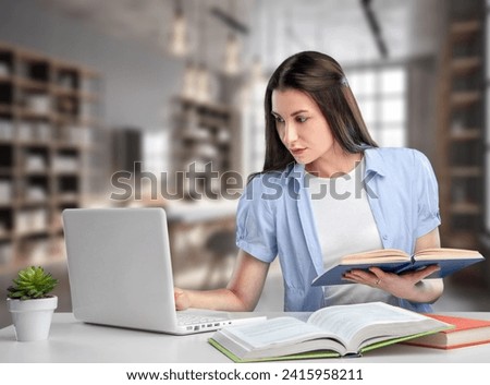 Pretty student girl preparing for exams in library. Royalty-Free Stock Photo #2415958211