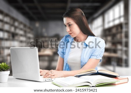 Pretty student girl preparing for exams in library. Royalty-Free Stock Photo #2415973421