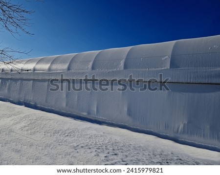 container building permanently forms a warehouse with offices. covered with a rubber sheet on a tent structure. ventilation with the help of a stainless steel propeller chimney. round, hangar Royalty-Free Stock Photo #2415979821