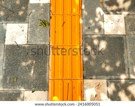Tiled guide for the blind on the road pavement