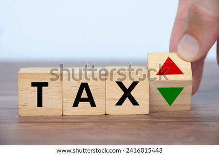 Hand turning blank wooden cubes with word tax. Taxation time concept