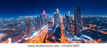 Night Panorama aerial top view of Dubai downtown skyscrapers with illuminated and highway. Business and financial modern district of city UAE.