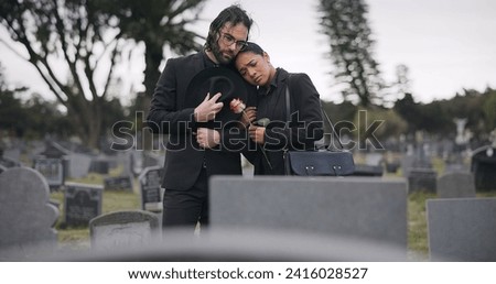 Couple, sad and mourning at tomb of graveyard, funeral and pay respect together outdoor. Death, grief and man and woman at cemetery by casket, empathy and interracial support to console at tombstone Royalty-Free Stock Photo #2416028527