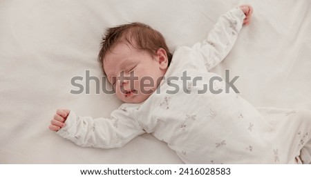 Cute, sleeping and newborn baby on a bed at a home in the bedroom for resting and dreaming. Tired, sweet and top view of infant, child or kid taking a nap in the morning in nursery at family house. Royalty-Free Stock Photo #2416028583