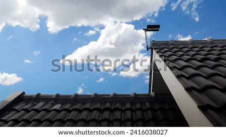 digital tv antenna installed on rooftop with blue sky background.