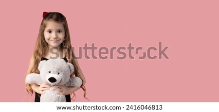 Happy child girl hugs a gray teddy bear, isolated pink background. Picture with space for text, image used for banners.