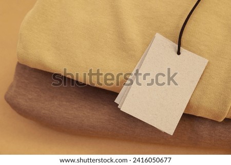 Garment with cardboard tag, closeup. Space for text