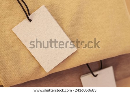 Cardboard tags on garment, closeup. Space for text