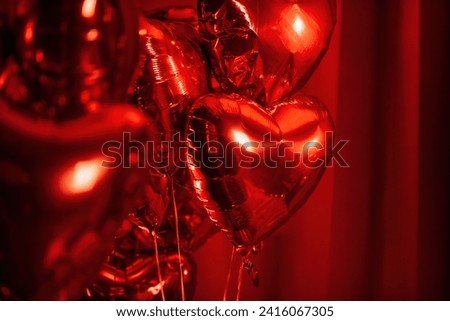 Extravagant glamour background with red foil heart air balloons for love party. Beautiful romantic burlesque room place for st valentines holiday illuminated vanity makeup mirror muffled light Royalty-Free Stock Photo #2416067305