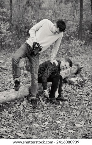 wedding photographer helps the groom put on his shoes, the guys are having fun