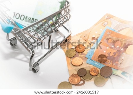Shopping cart with euro banknotes on white. Consuming concept. High quality photo