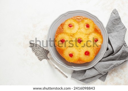 Homemade pineapple upside down pie with candied cherries . Tropical dessert on white background. Top view Royalty-Free Stock Photo #2416098843