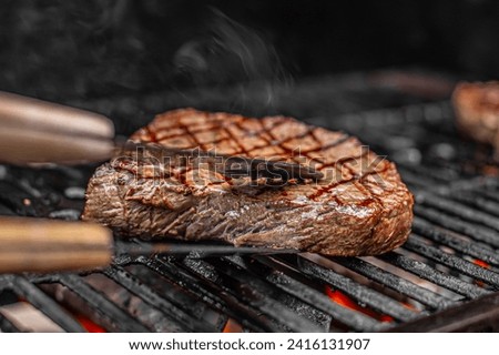 sizzling steak cooking on the grill  Royalty-Free Stock Photo #2416131907