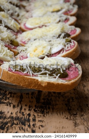 wrapped sandwich in a bowl, ham, cheese, cucumber, eggs on a wooden background.

