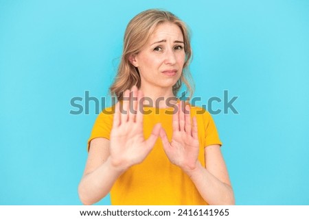 Ew, so gross. Young woman with disgust expression repulsing something. Concept of human reactions and emotions. Female make refuse gesture standing standing isolated on blue background